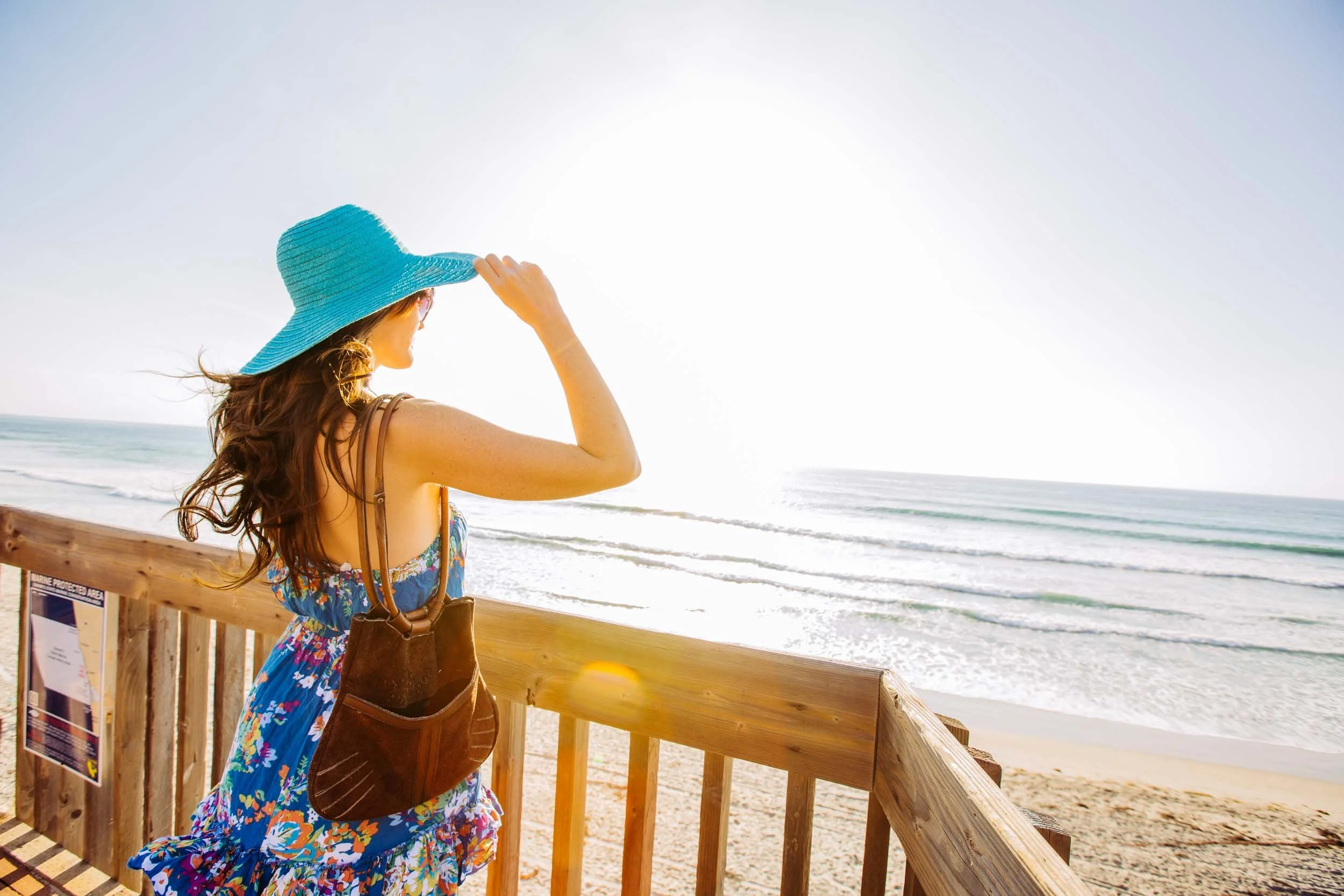 Woman-in-Blue-Hat-Looking-at-Ocean-from-Deck.jpg