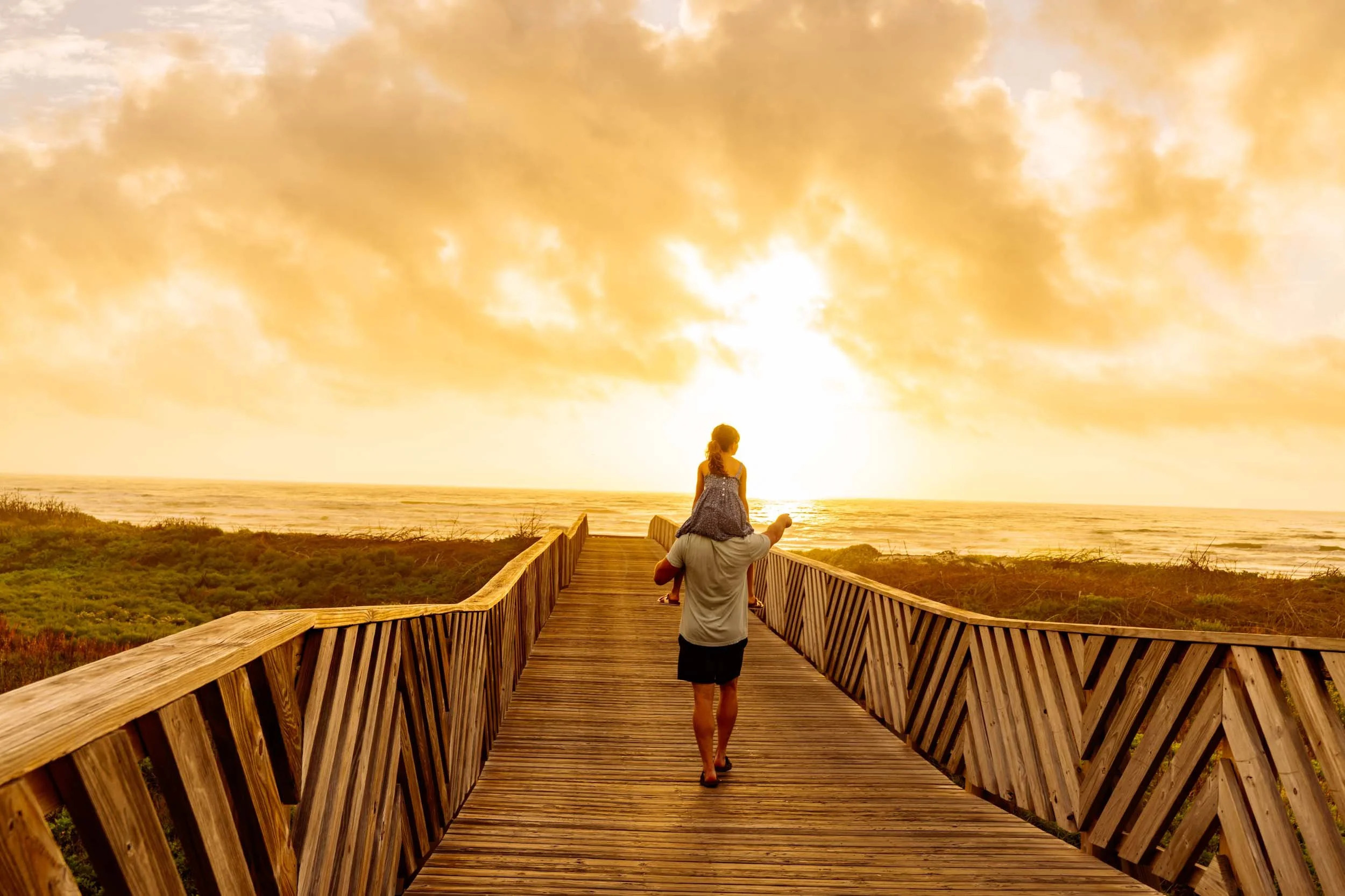 Girl-on-Mans-Shoulders-for-Sunrise-Walk-on-Boardwalk.jpg