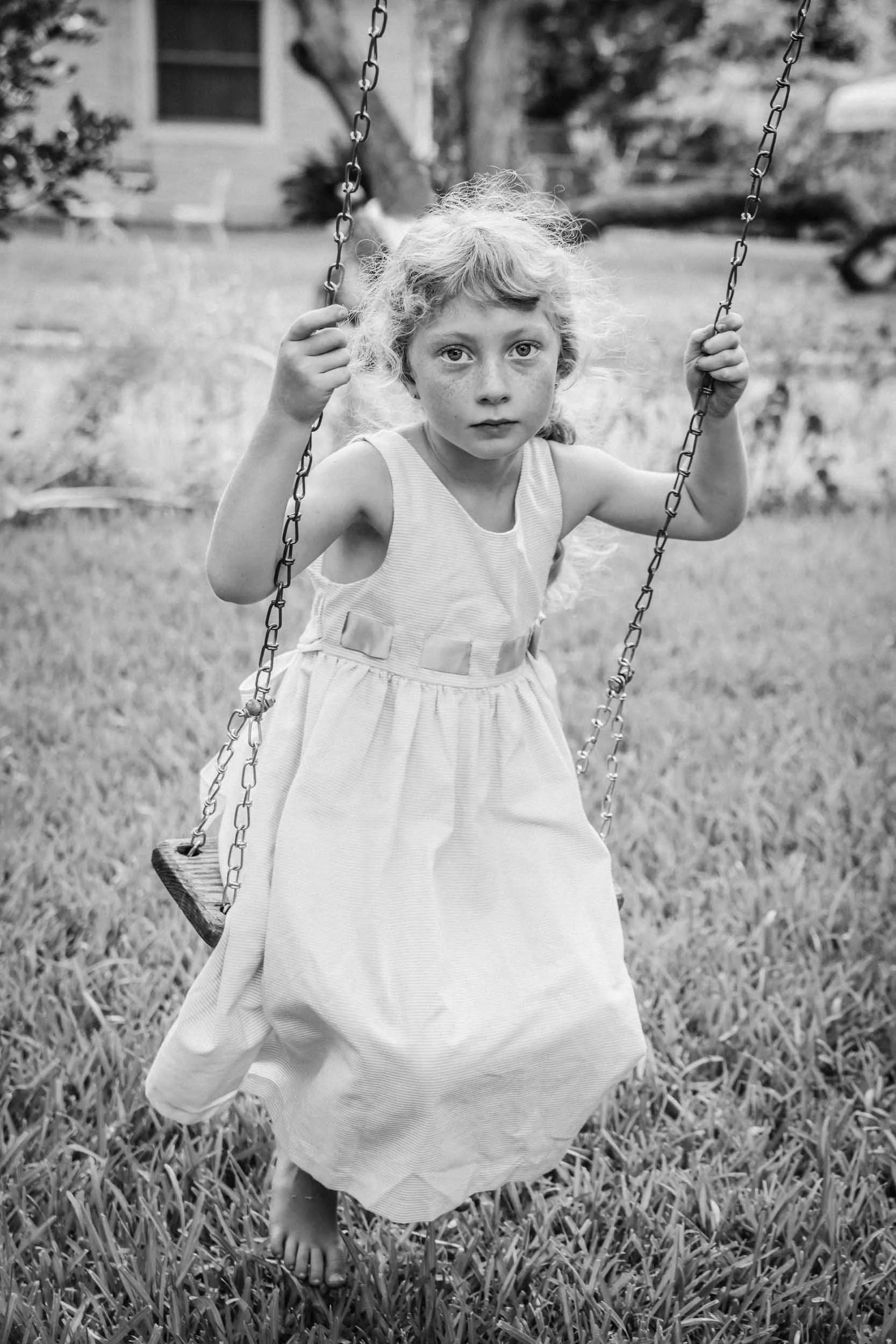 Girl-in-dress-on-swing-in-yard.jpg