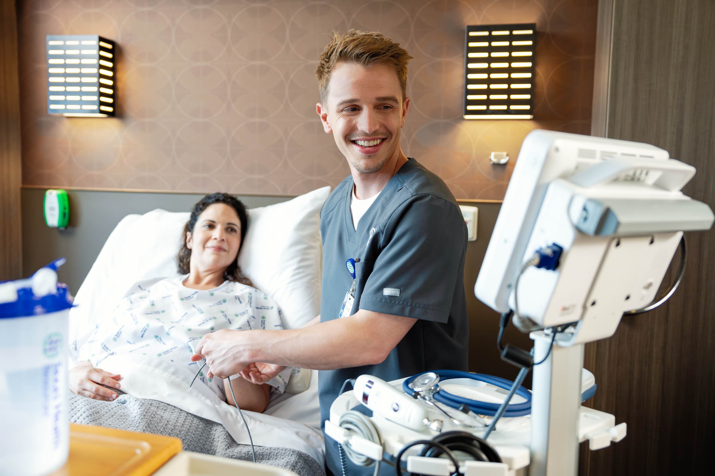 Smiling-Nurse-Monitoring-Patient-in-Hospital-Room.jpg
