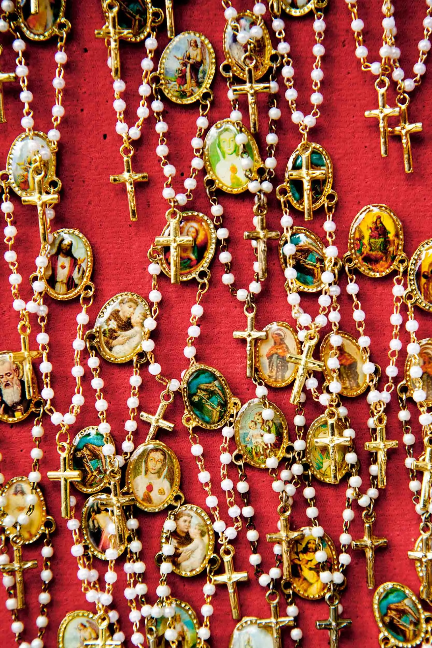 Rosaries-with-Religious-Icons-on-Red.jpg
