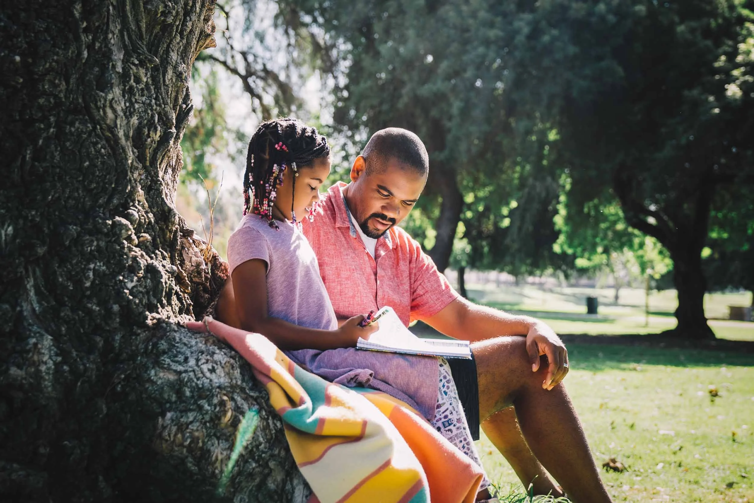 Man-and-Daughter-Studying-in-the-Park.jpg
