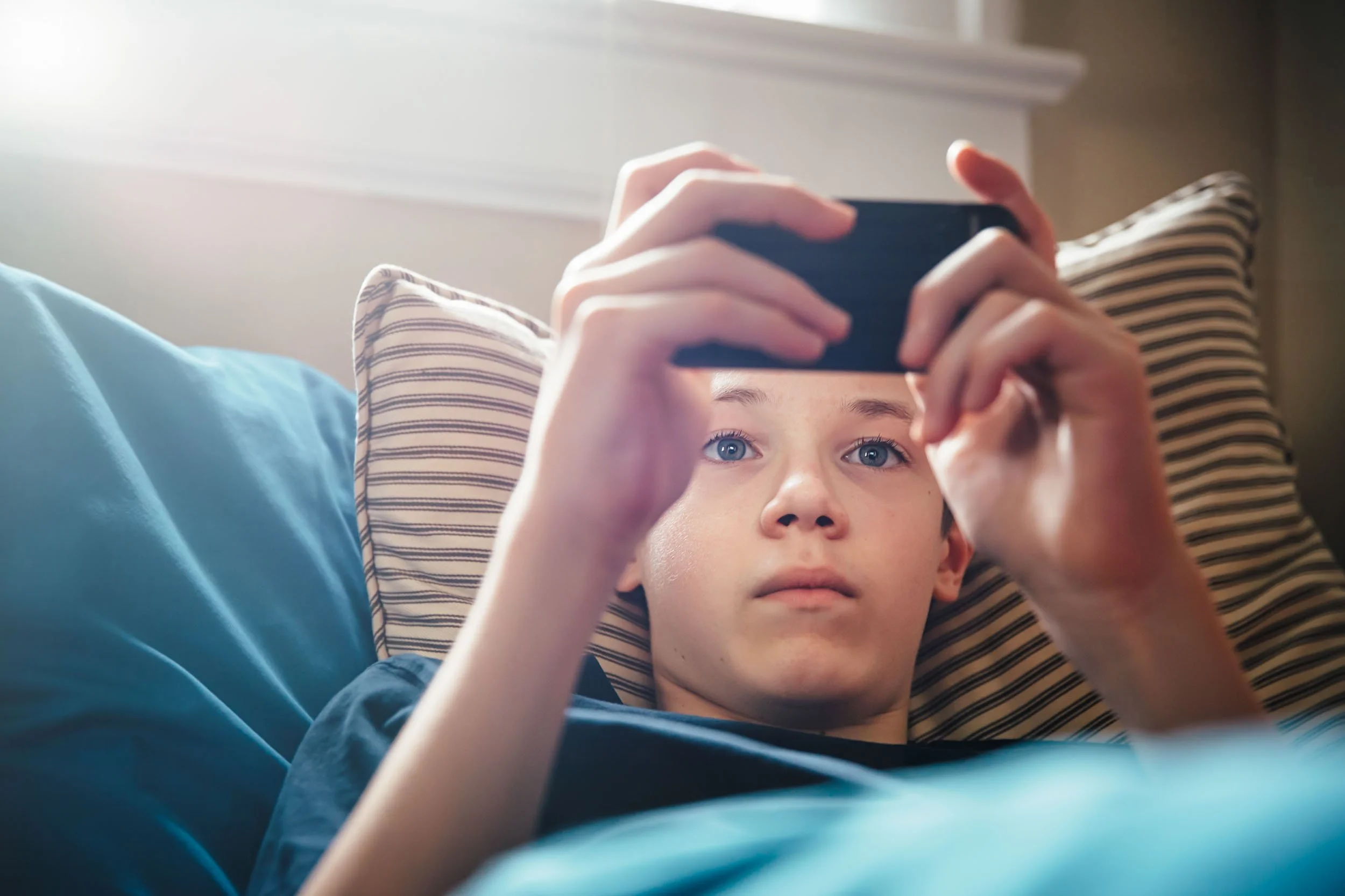 Teen-Boy-Using-Smartphone-in-Bed.jpg