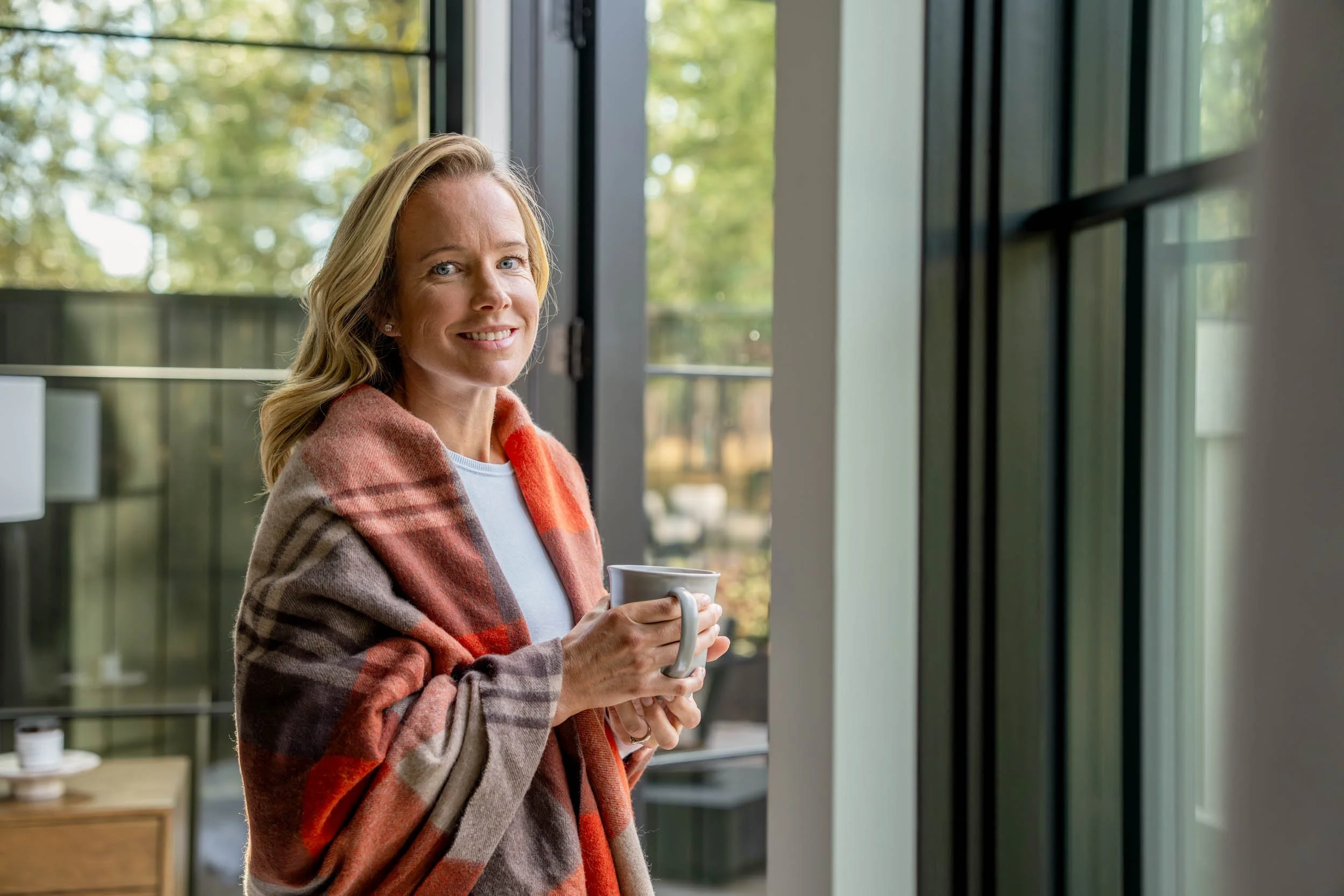 Smiling-Woman-Wrapped-in-Blanket-Holding-Mug.jpg