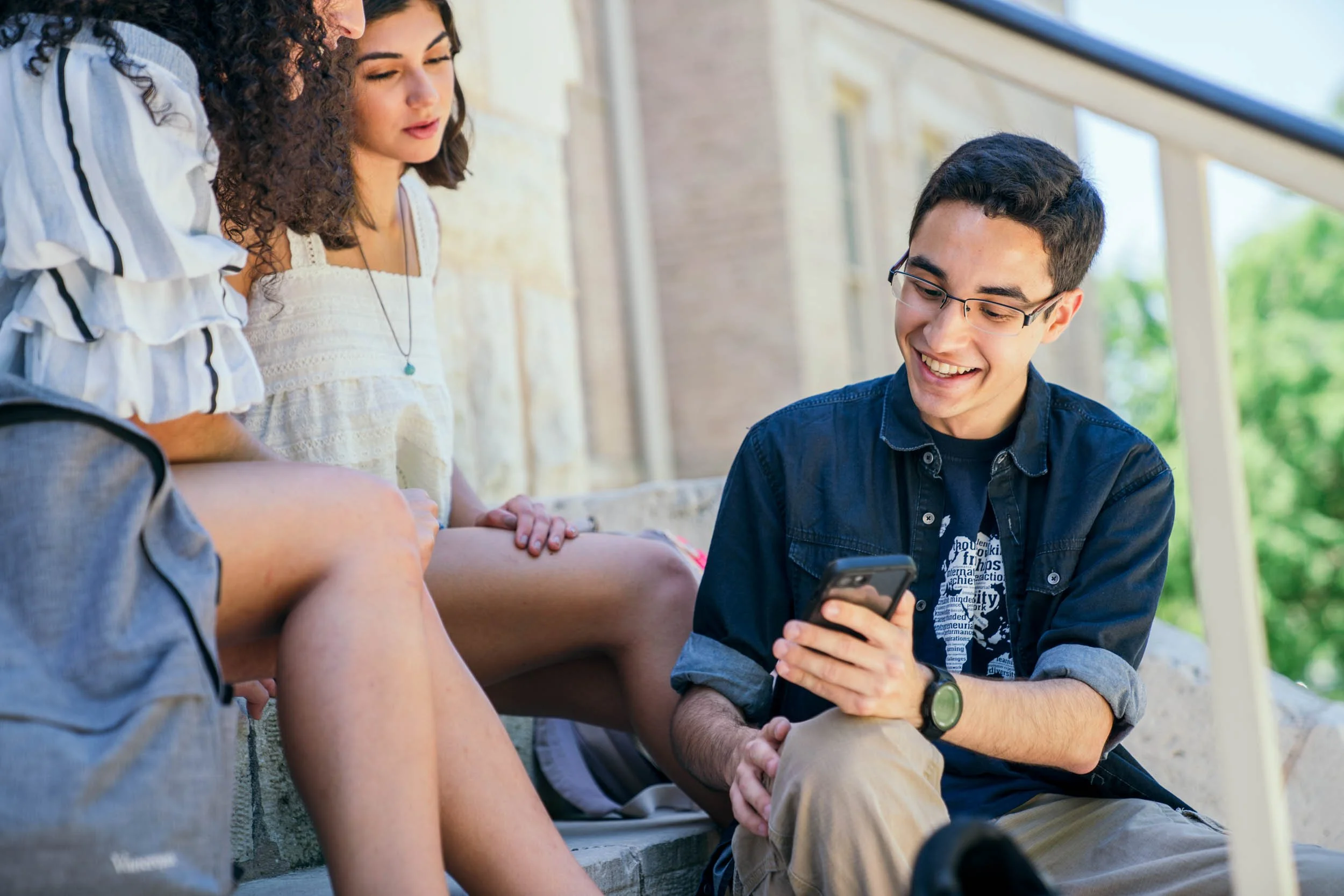 College-Students-Looking-at-Cell-Phone-Outside.jpg