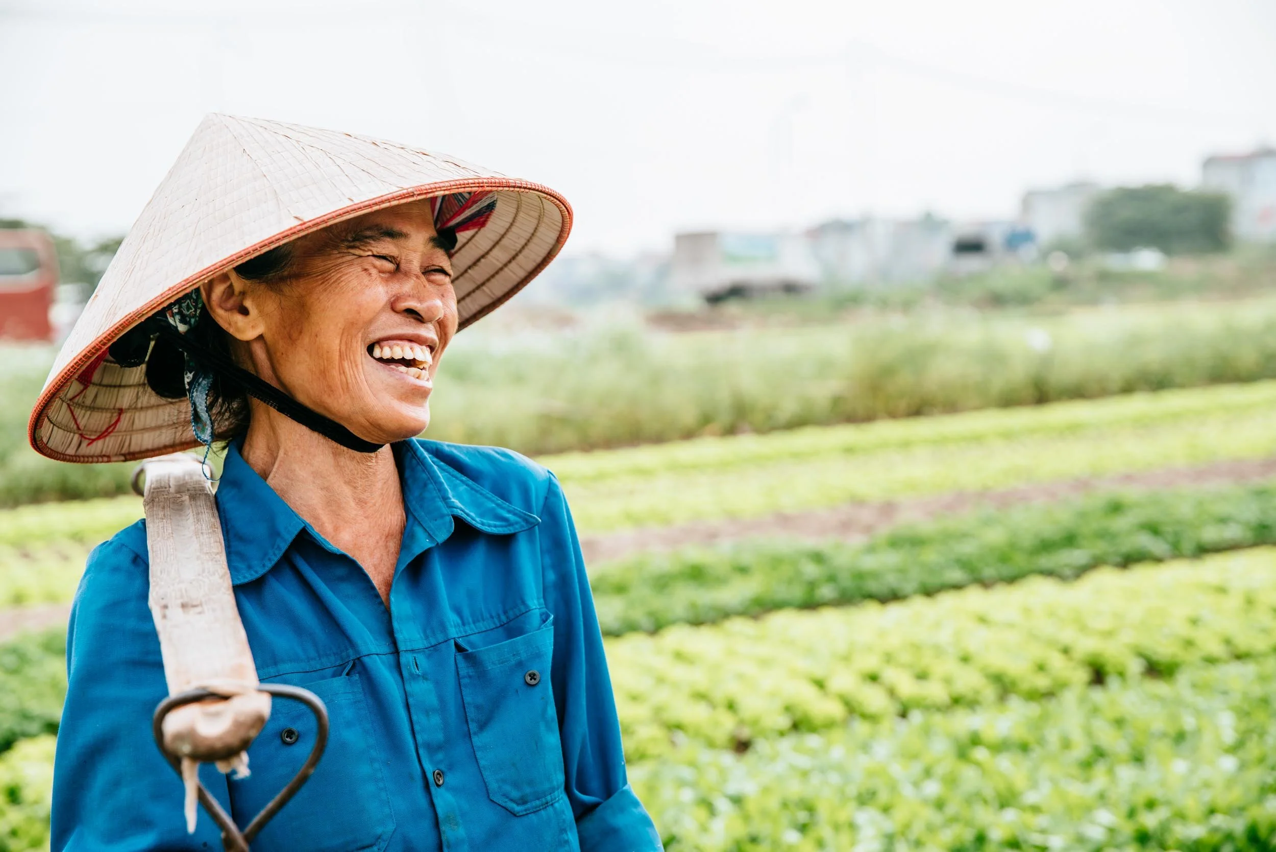 Woman-in-Field-with-Hat-Laughing.jpg