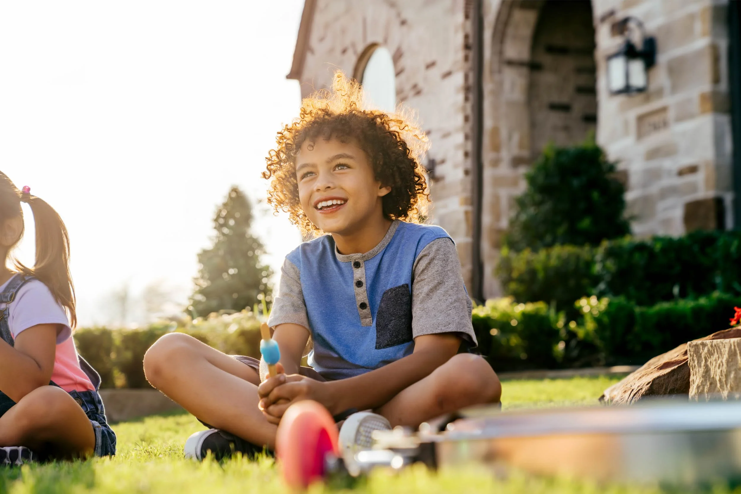 Boy-Sitting-Outdoors-Smiling.jpg