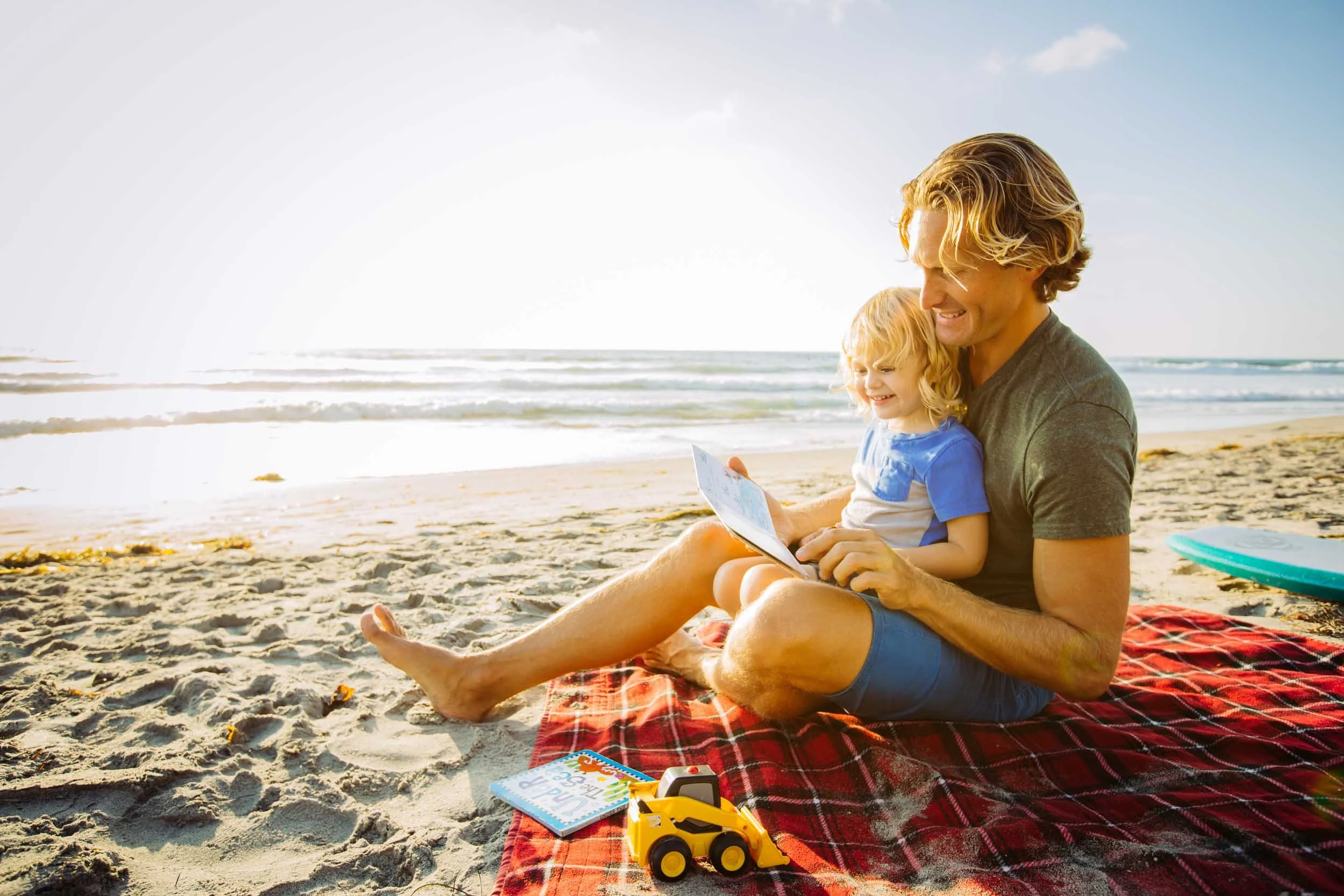 Man-Reading-to-Child-at-Beach.jpg