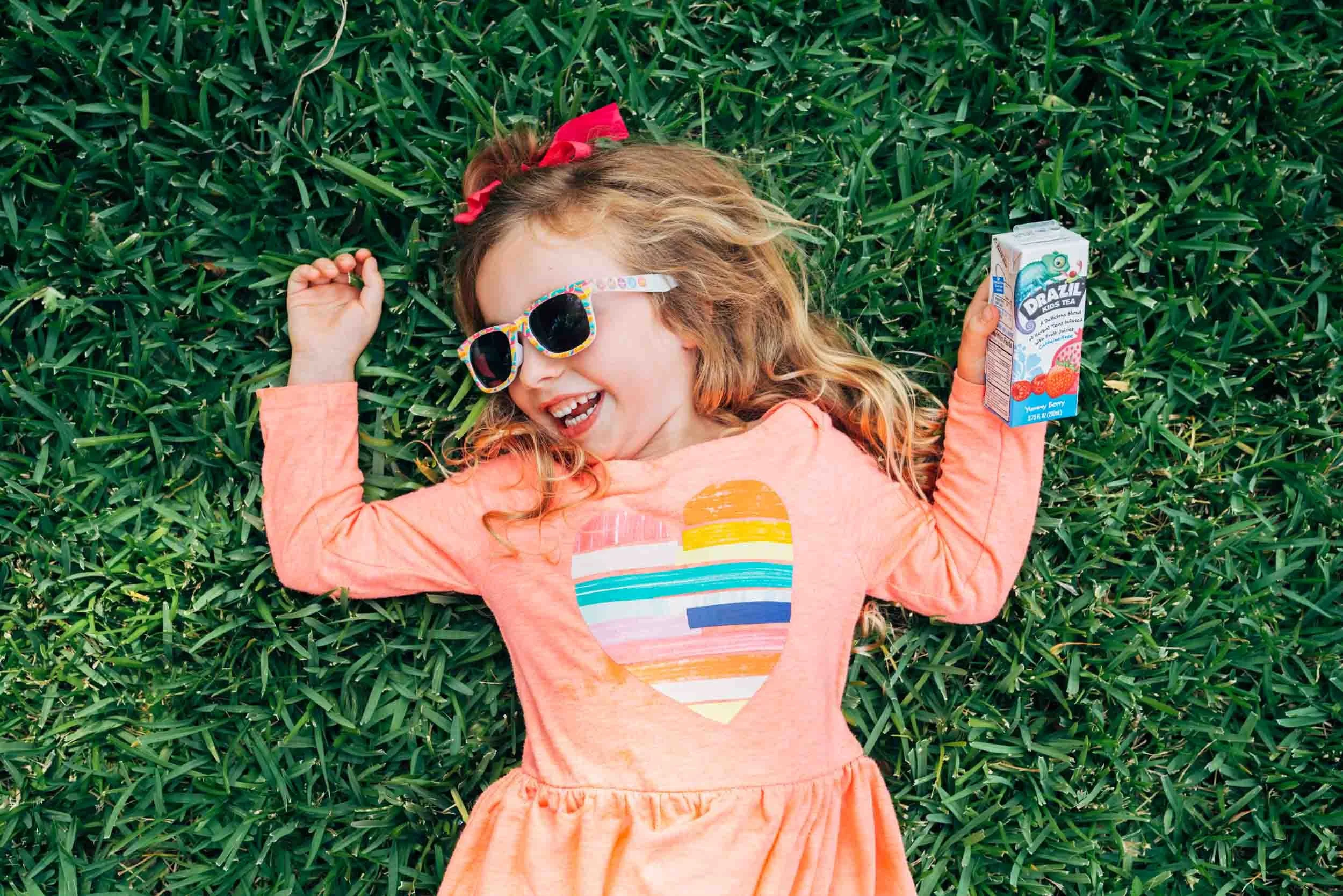 Girl-Laying-on-Grass Holding-Drazil-Drink-Box.jpg