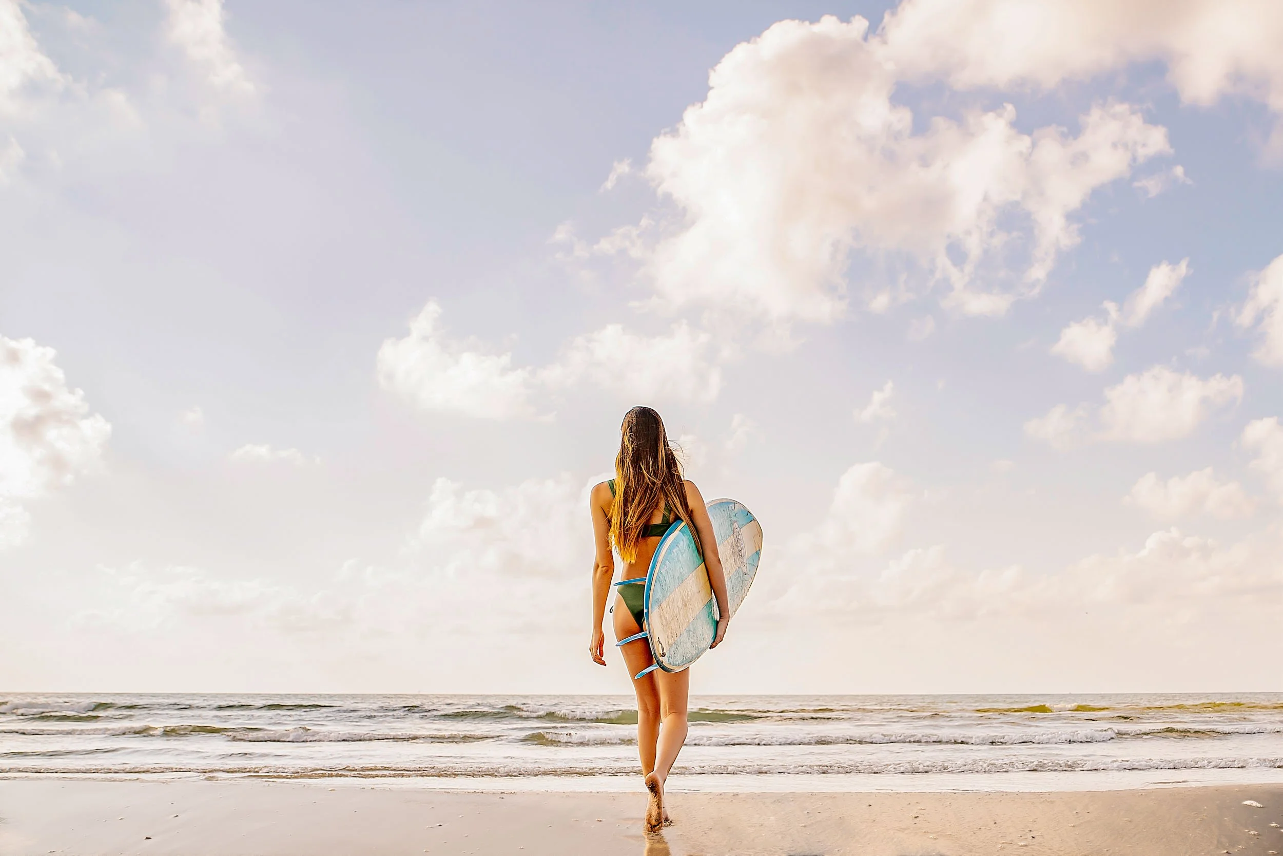 Woman-Walking-With-Surfboard-to-Ocean.jpg