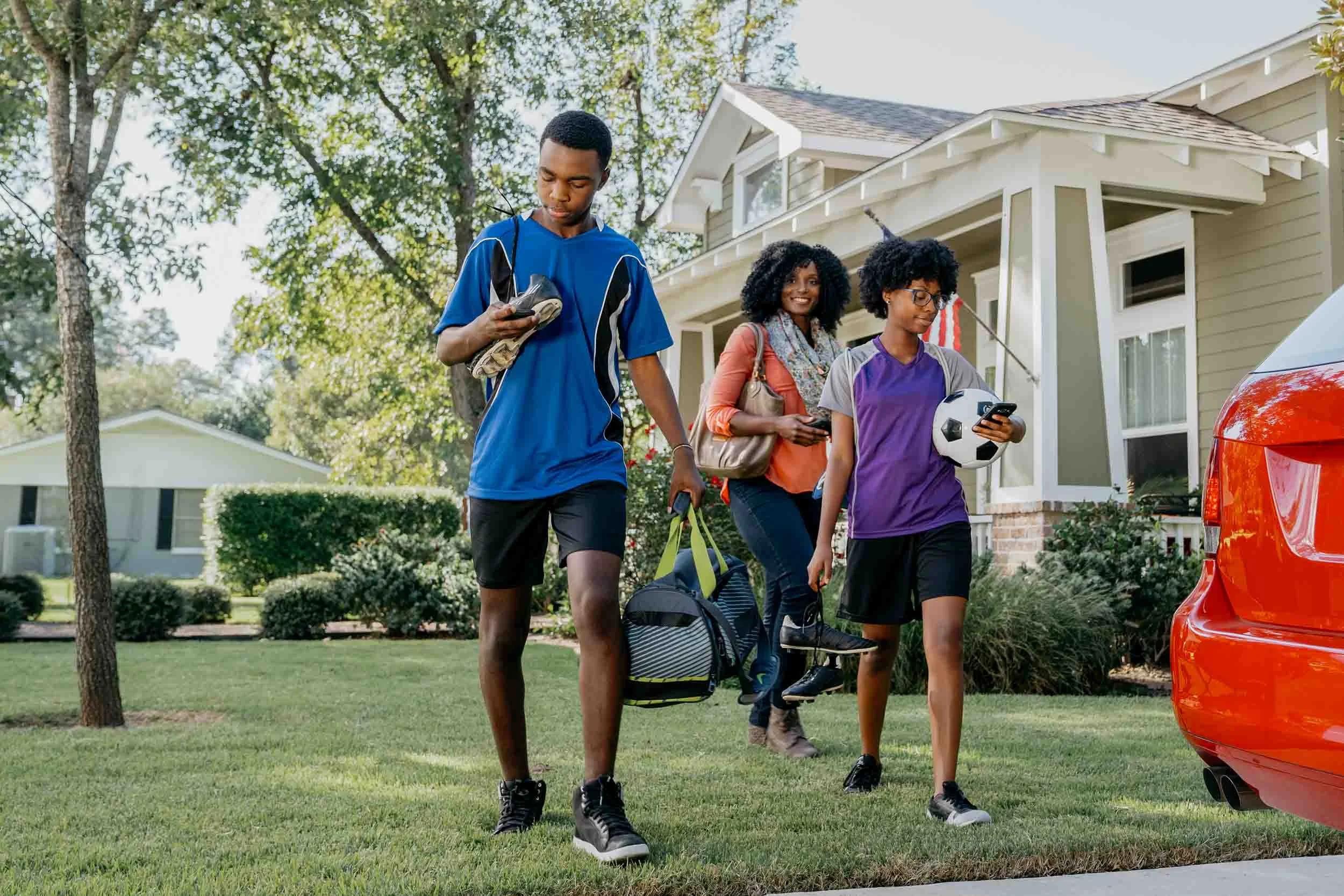 Kids-in-sports-attire-walking-to-car-with mom.jpg