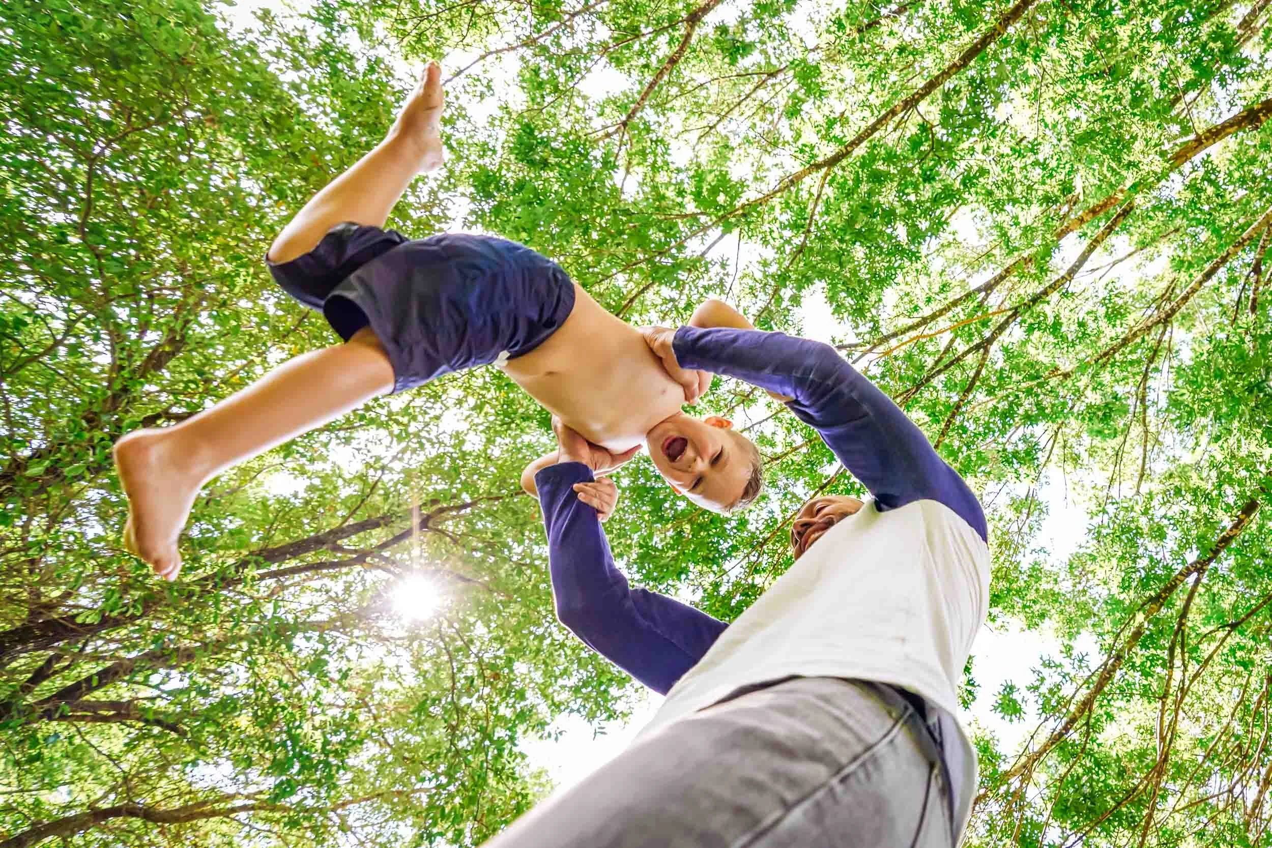 Dad-Swinging-Boy-Under-Trees.jpg