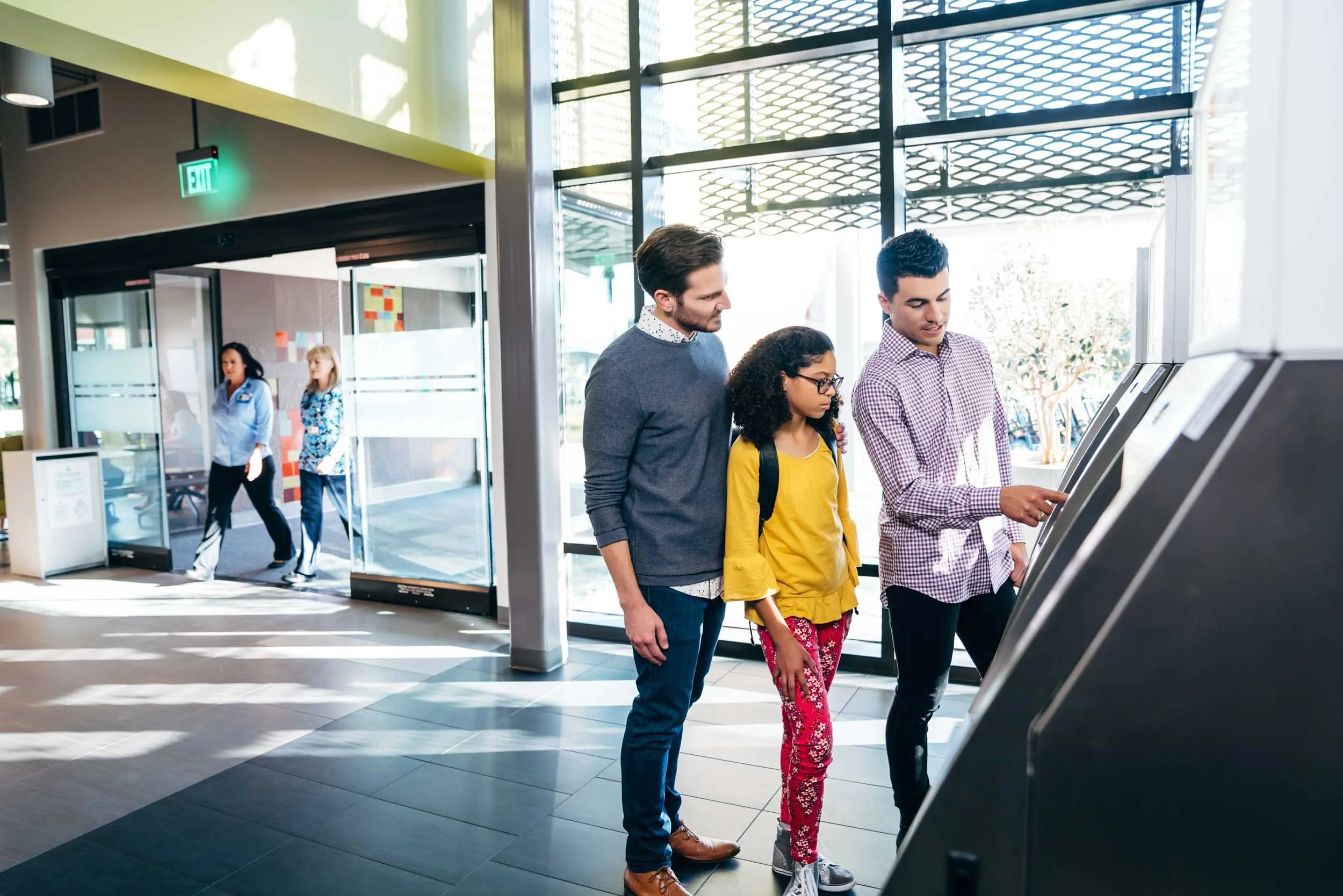 Gay-dads-checking-daughter-into-hospital-at-kiosk.jpg