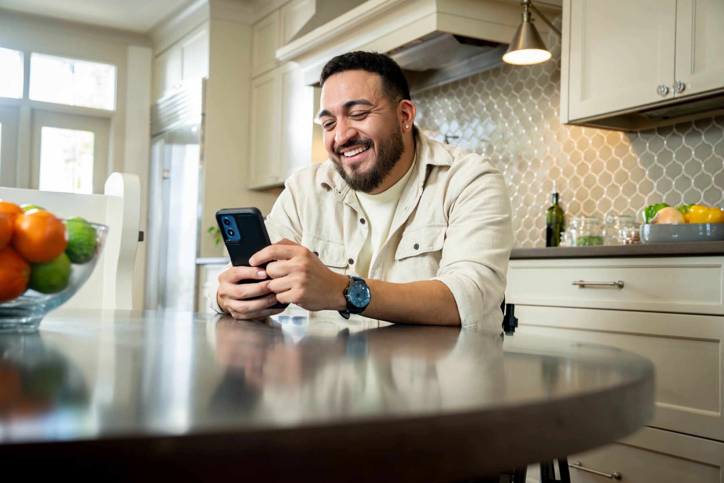 Man-Enjoying-Smartphone-in-Kitchen.jpg
