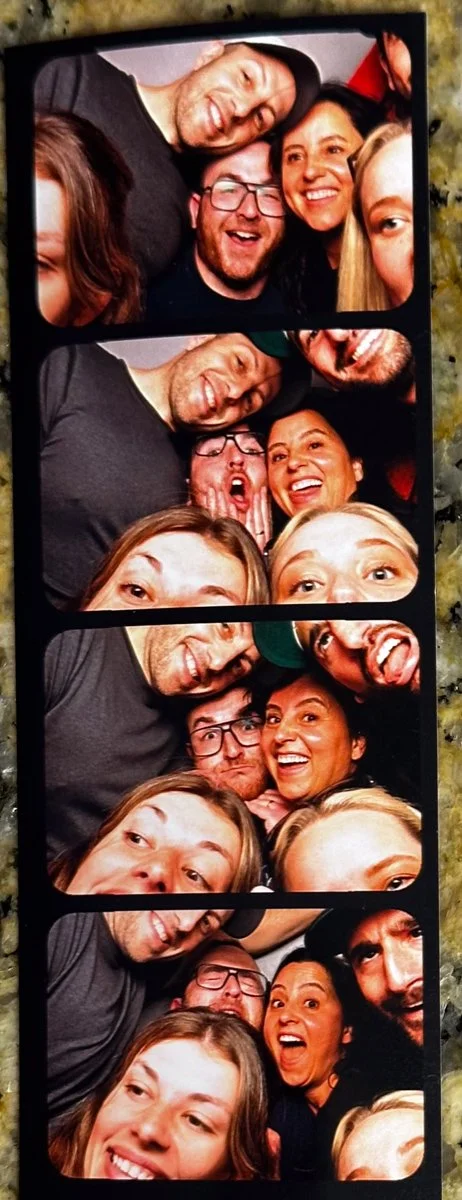Group of friends taking playful photo booth pictures together, making funny faces and smiling.