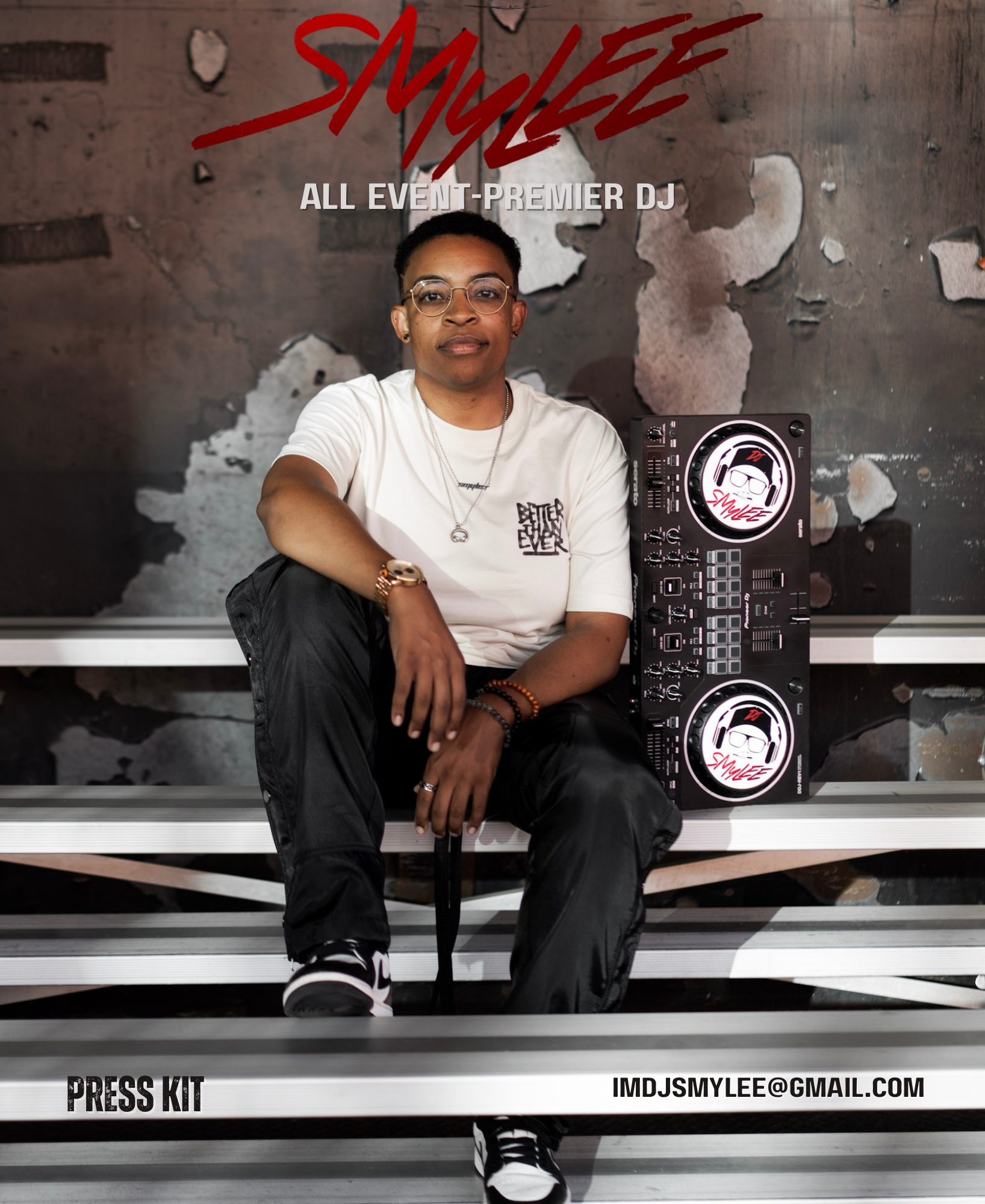DJ Smylee sitting on metal bleachers with a DJ equipment setup beside her, wearing glasses, a white t-shirt, black pants, and sneakers, in front of a graffiti wall with the word 'SMYLEE' written in red.