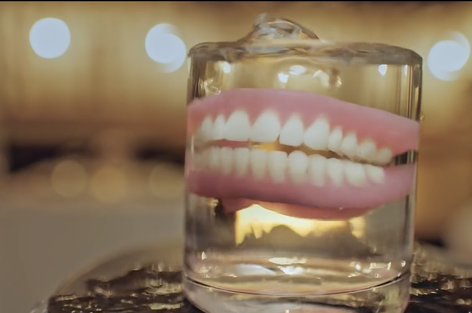 A glass filled with water contains a pair of dentures