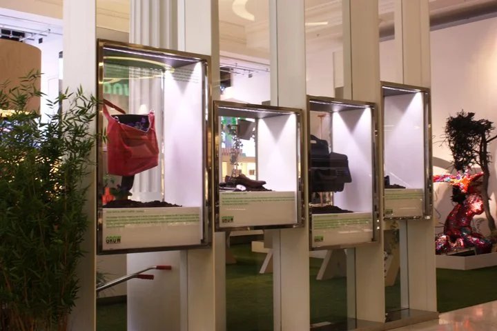 Display cases with various retail items, including a red bag, plastic accessories, and decorative horse sculpture in the background.