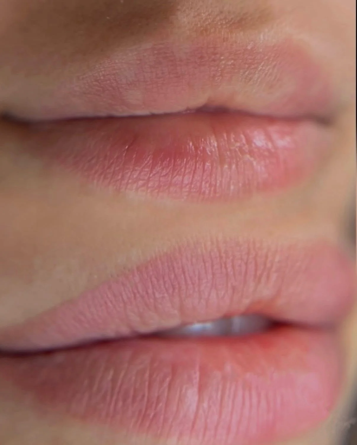 Close-up of pink, slightly parted lips with natural texture.