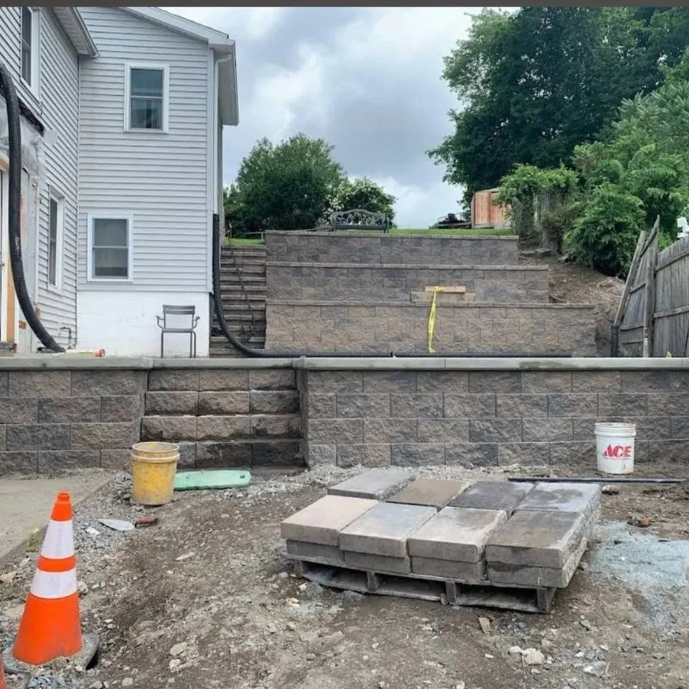 A staircase under construction with stone retaining walls and pavers, in a backyard, multi-level, multi level, multilevel. versa lock, versalock, terrace