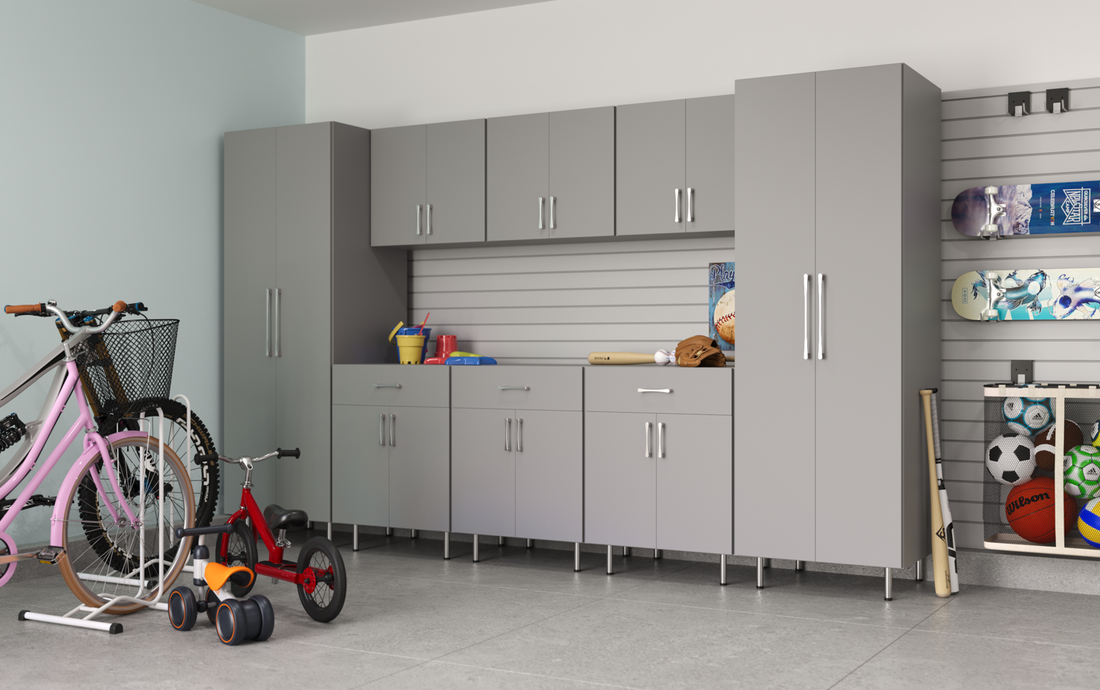 A garage with gray storage cabinets, children's toys, sports equipment, and bicycles.