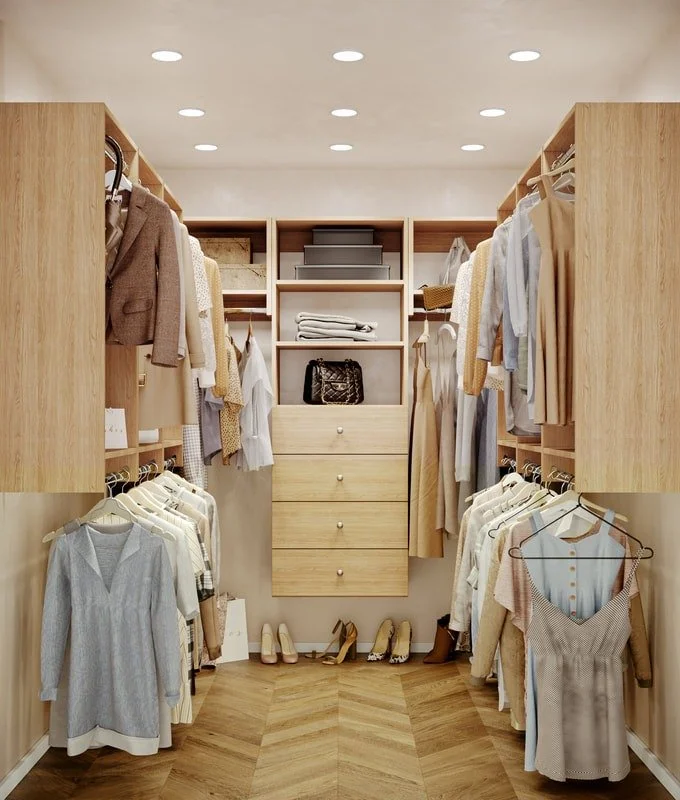Walk-in closet with shelves, hanging clothes, and shoes on the floor.