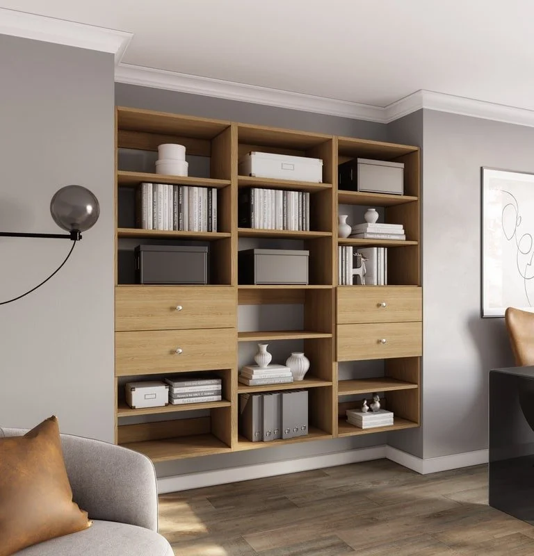 wooden bookshelf with open shelves and drawers, decorated with books, white vases, boxes, and binders