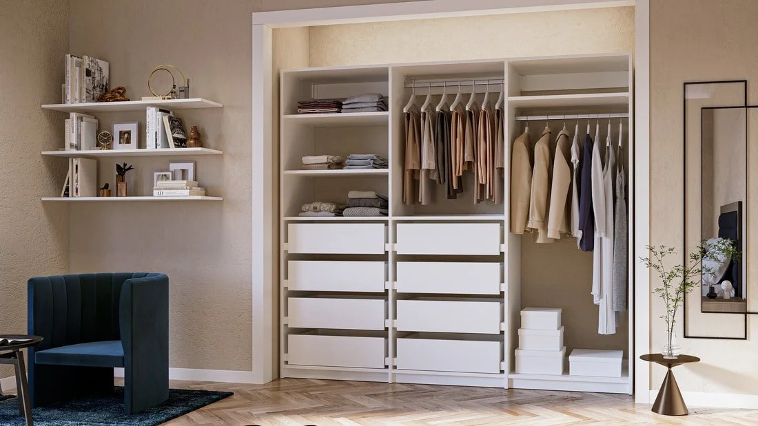 Modern bedroom closet with organized clothing and storage drawers, adjacent shelves with books and decorative items, in a well-lit room with beige walls and wooden flooring.