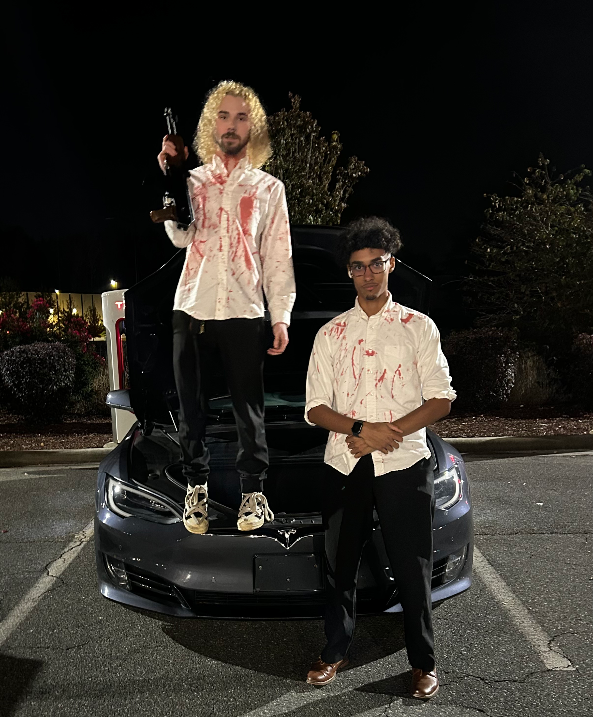 Ainsley4x, and Jahsia4x, standing in front of Ainsley's Tesla. Photo taken on October 31st, 2025. Halloween