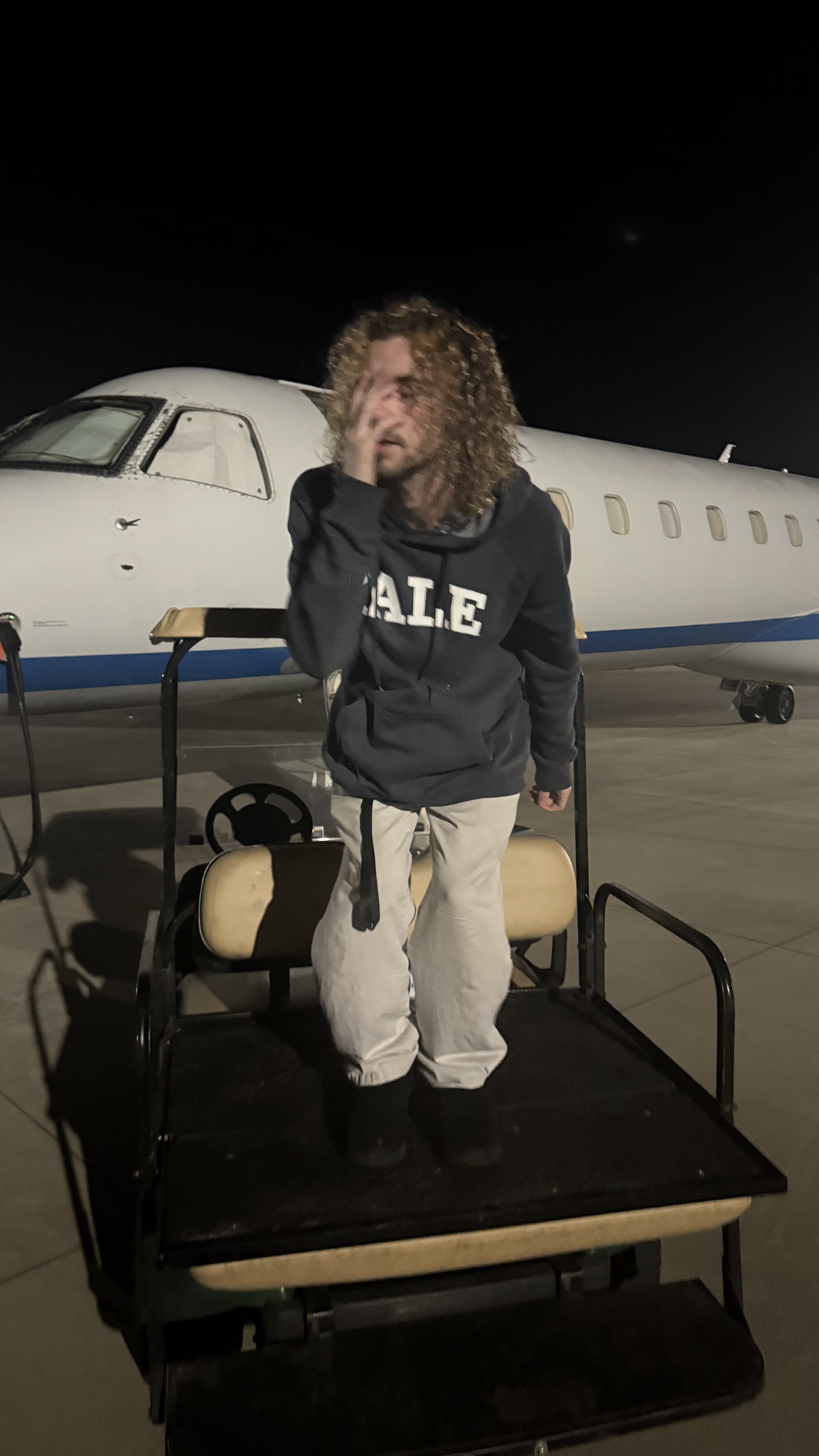 Ainsley4x pictured on October 10th, 2025, at Statesville Regional Airport, on a Golf Cart, in front of an Embraer ERJ-145.