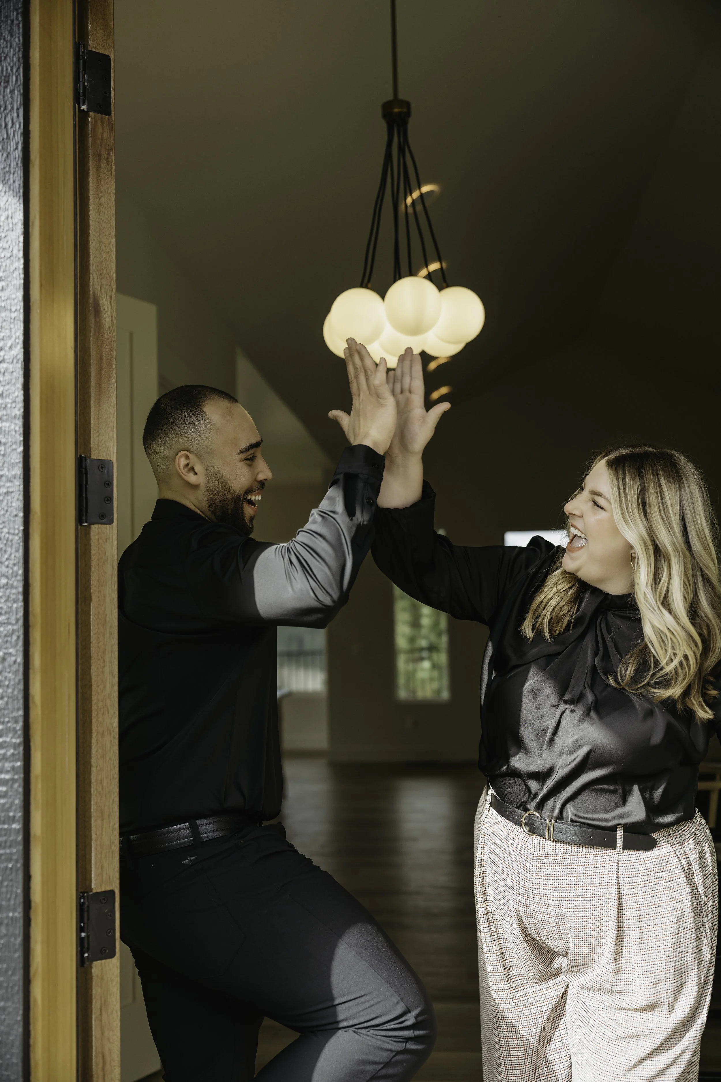 Husband and Wife high fiving over confidently helping spokane residents buy and sell confidently in spokane, wa