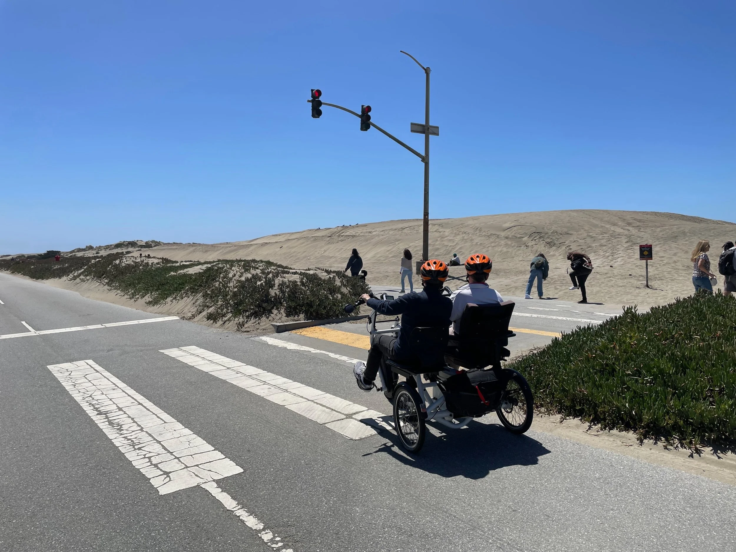 two people riding a side-by-side electric-assist tandem bike