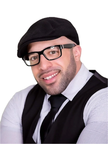 A man wearing a black beret, glasses, a light-colored shirt, a black vest, and a tie, smiling at the camera.