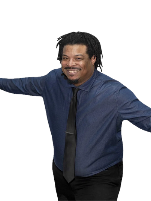 A man smiling with his arms outstretched, wearing a dark blue shirt and black tie.