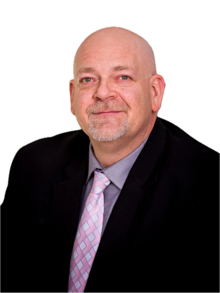 A portrait of a middle-aged man with a bald head, beard, and mustache, wearing a dark blazer, light shirt, and pink patterned tie, against a plain background.