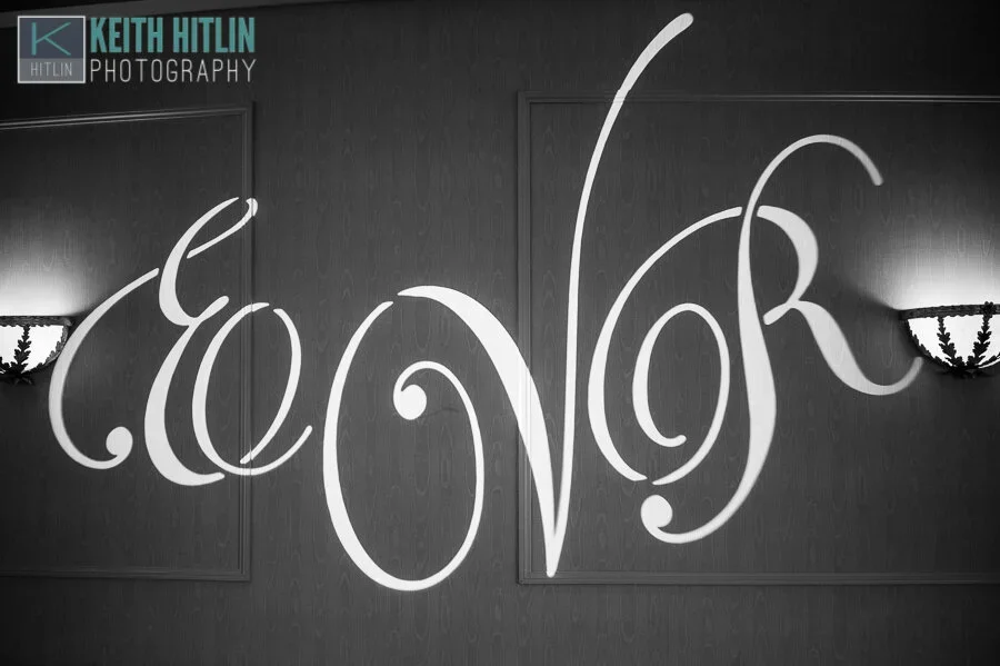 Decorative wall with the word 'LOVE' written in ornate cursive script, flanked by two wall-mounted lamps.