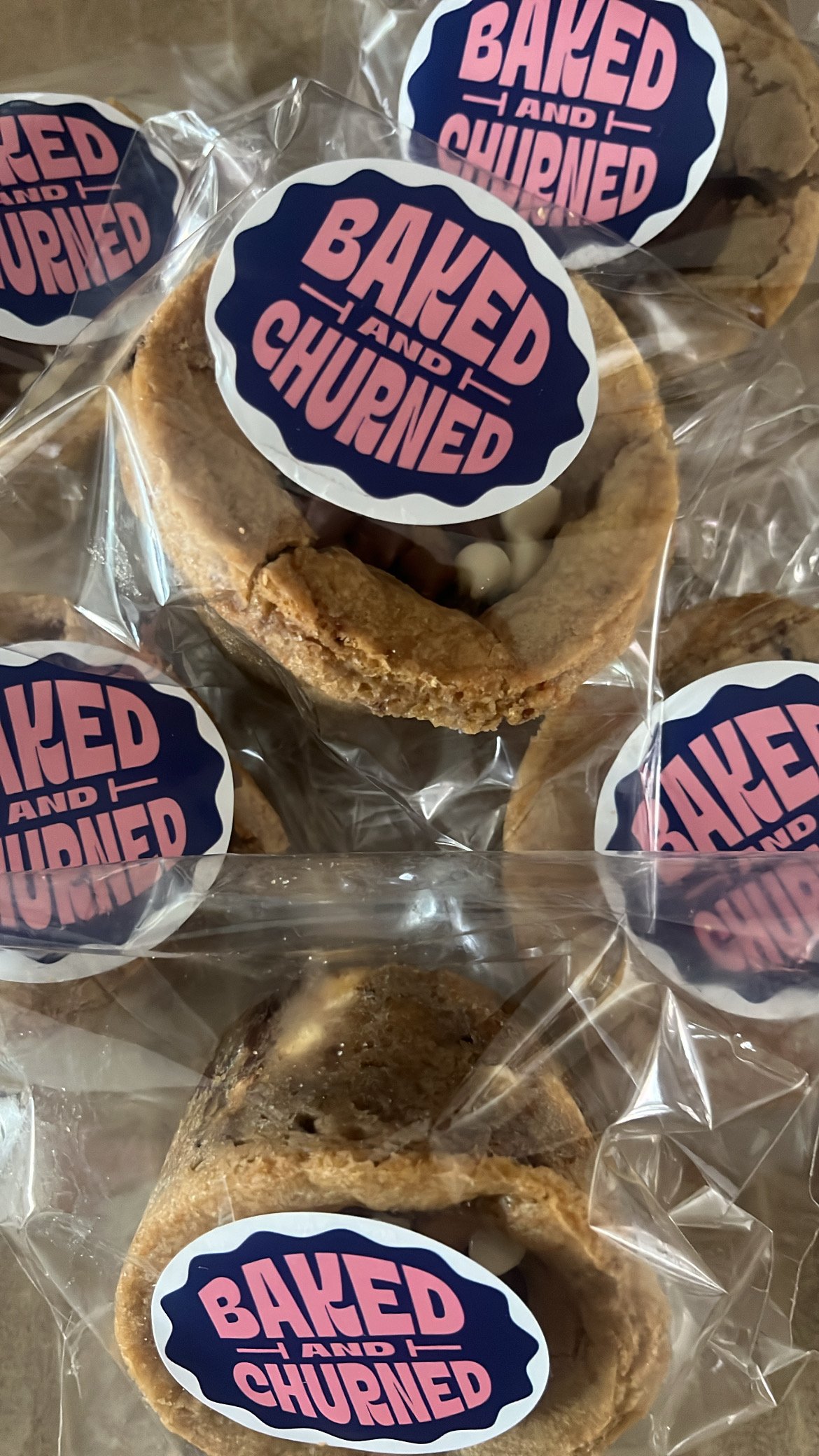 Baked and Churned cookies in clear plastic packaging with a round sticker label.