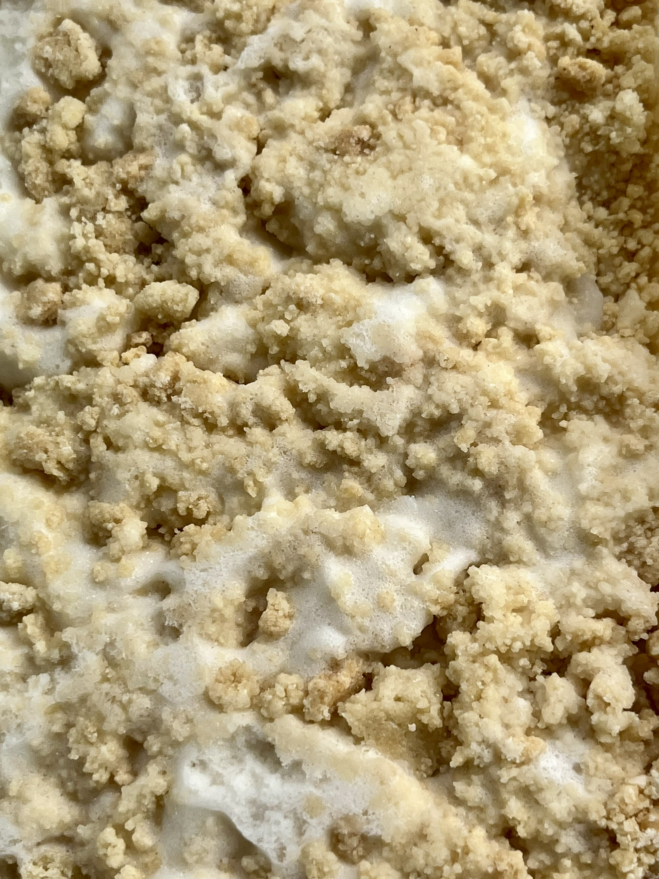 Close-up of shortbread pieces crumbled over vanilla ice cream.