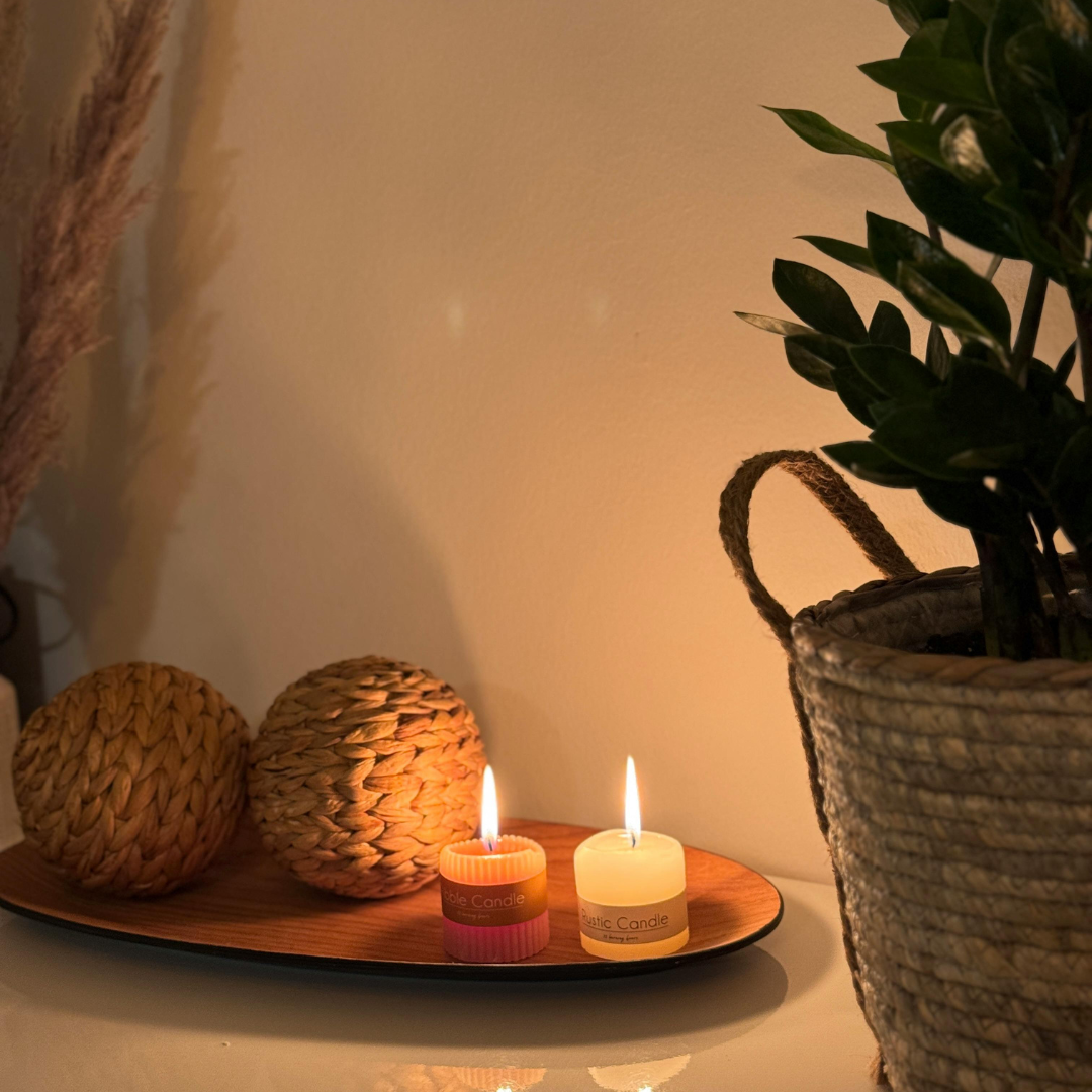 two candles softly lighting up on a wooden tray