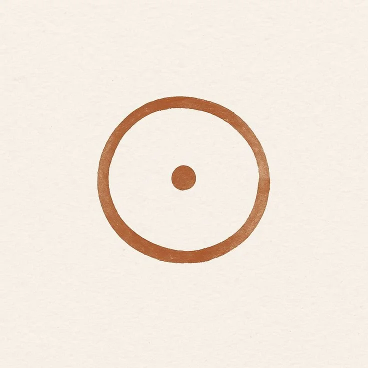 A simple drawing of a brown circle with a smaller brown dot inside it, resembling a target or bullseye.