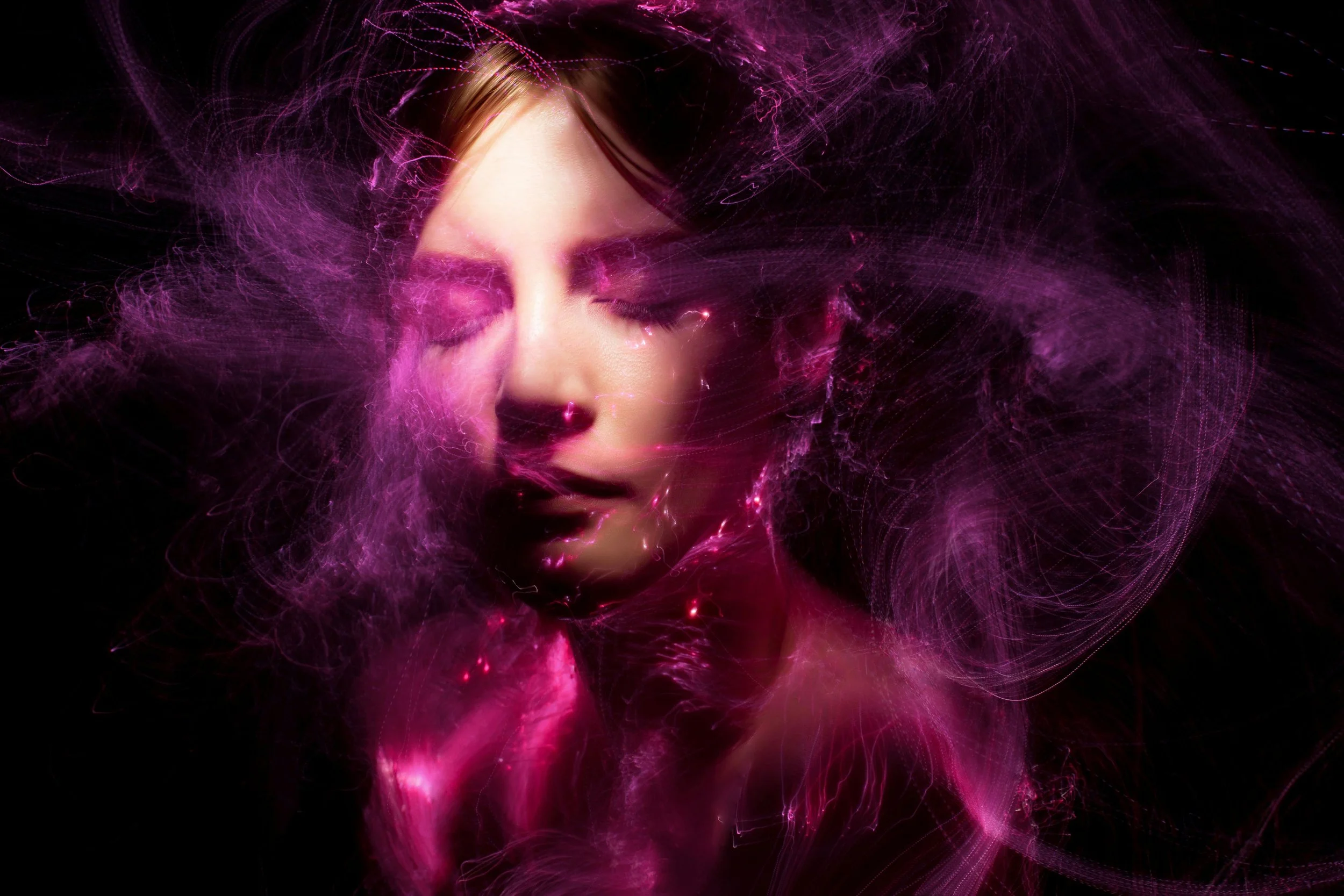 Photo très artistique montrant le visage et le cou d'une femme entourée d'un tourbillon de lumière rose et mauve sur fond noir illustrant la méditation Entre deux souffles de Zen découverte, pour diminuer stress, anxiété et favoriser la concentration