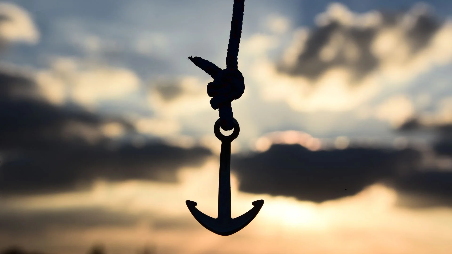 Ancre suspendue devant un ciel flouté de lever de soleil, illustrant la méditation Ancrage au quotidien pour débutants, pour revenir à l’instant présent, ressentir stabilité, calme et contact avec le corps.