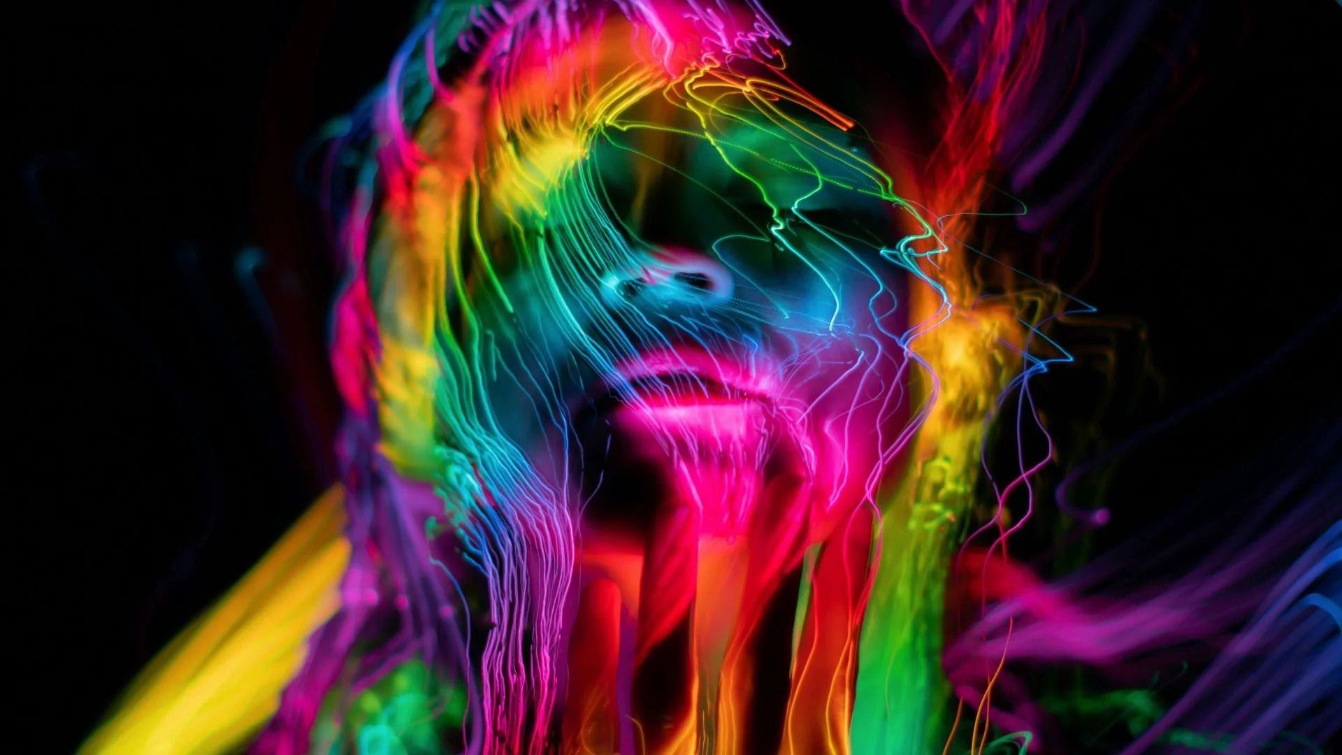 Visage d’une femme de face avec des coulées de couleurs vives sur fond noir, illustrant la méditation Pause improbable pour adolescents, pour ramener conscience et voir la vie différemment.