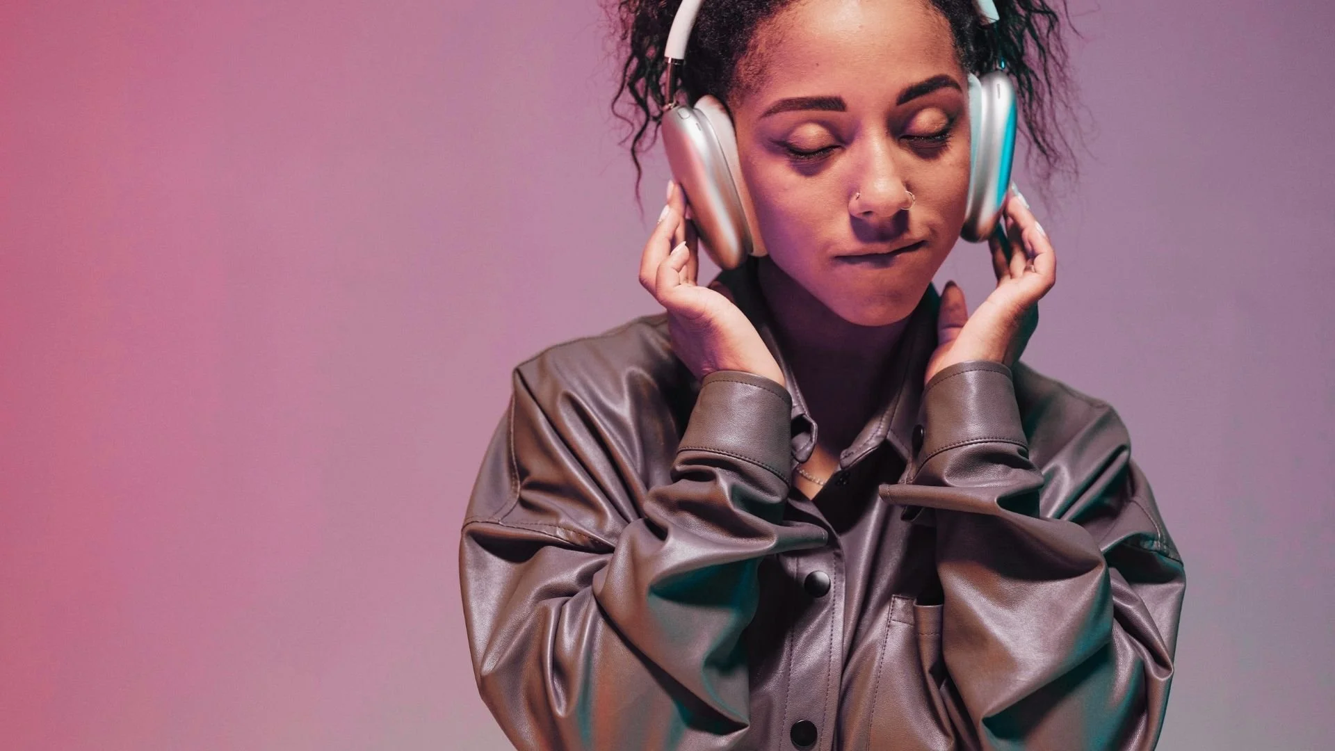 Femme au teint basané, les yeux fermés avec des gros écouteurs sur la tête, elle a une expression très calme et zen, sur un fond violet, illustrant la categorie Zenitude 101avec des meditations courtes conçues pour initier en douceur les debutants.