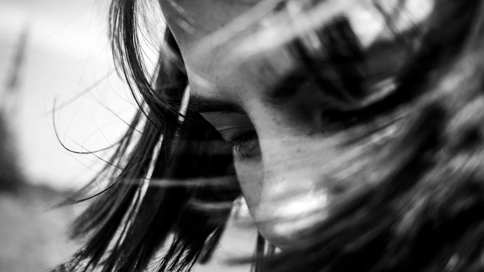 Gros plan d’une jeune femme noir et blanc, du front au nez, cheveux au vent, illustrant la méditation Première respiration pour débutants, pour poser le souffle, ralentir et installer le calme.