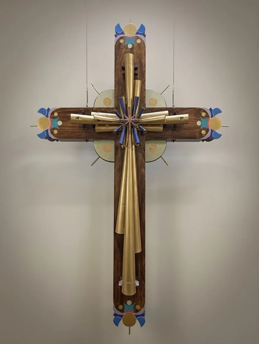 A large, decorative wooden cross with colorful accents, gold pipes, and blue and gold details.