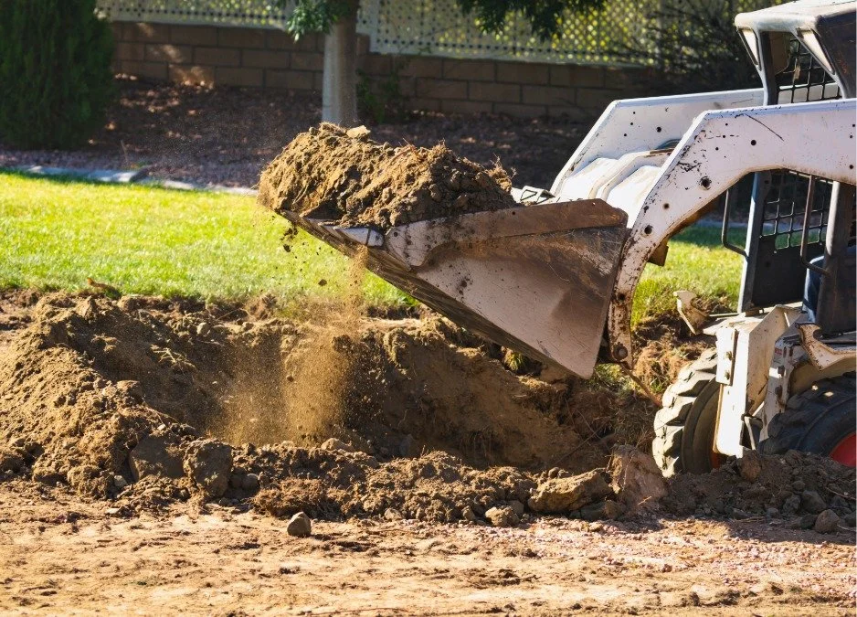 Small excavator moving dirt to prep for landscaping construction done by a Central Oregon landscaping company