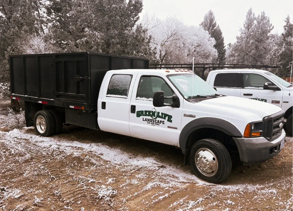 A dump truck utility vehicle with GreenLife Landscaping branding as a part of landscaping utility vehicle fleet