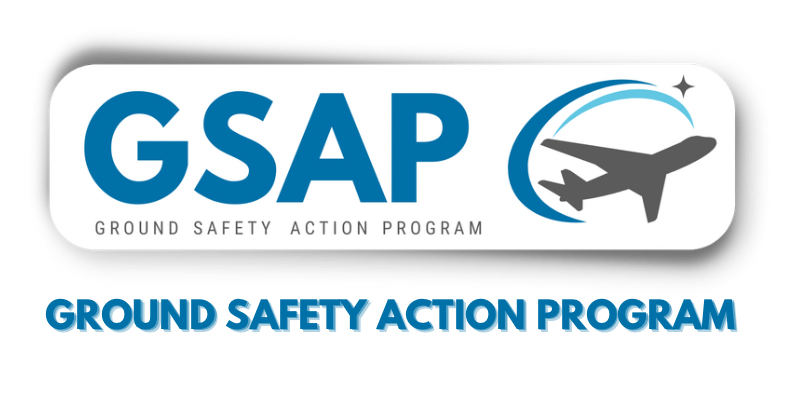 Close-up of the side of a large, multicolored racing yacht with red, white, blue, and black stripes, against a blue sky with a few clouds.