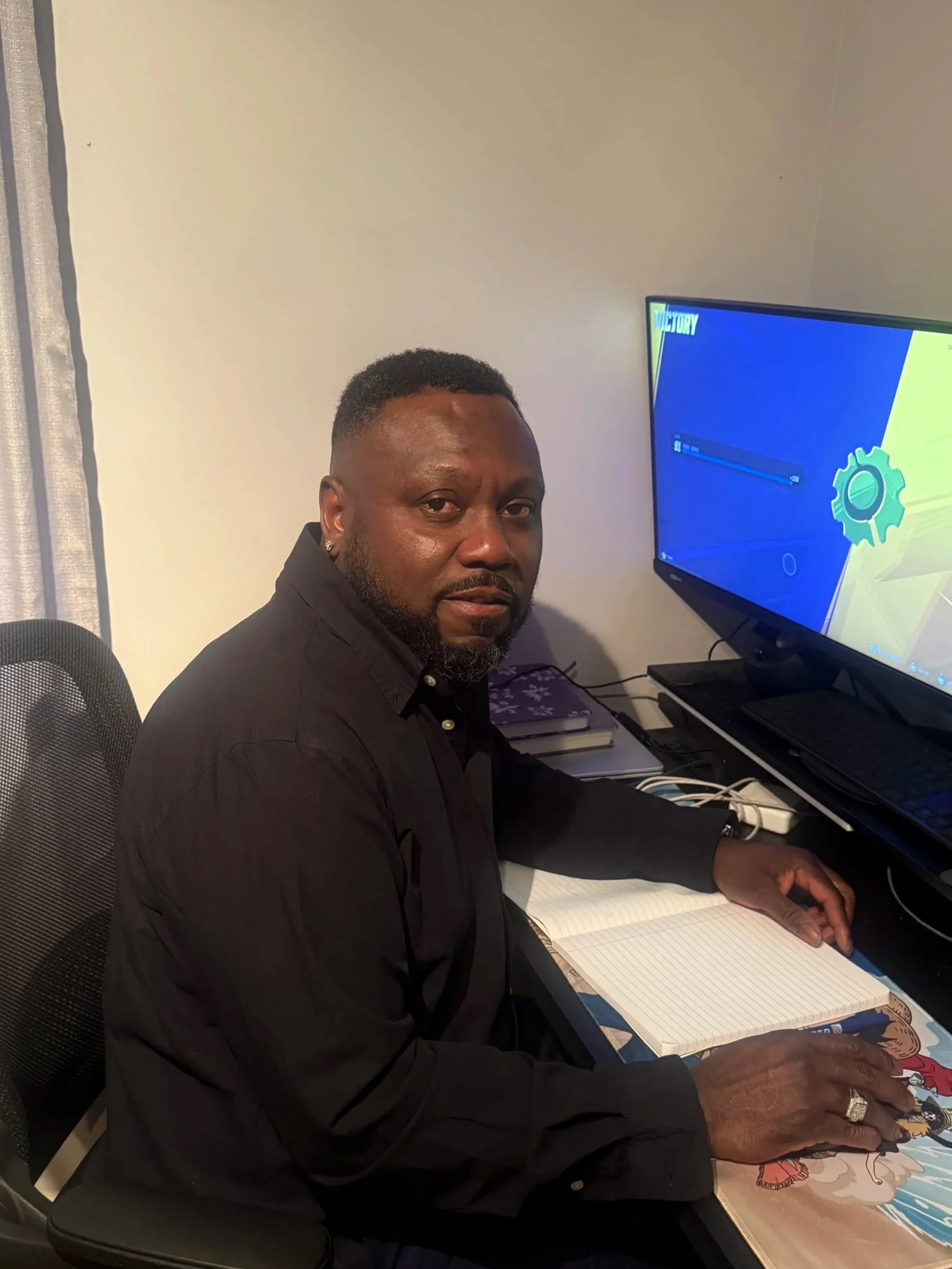A young African American man in a suit and tie looking directly at the camera with a neutral expression in a professional setting.